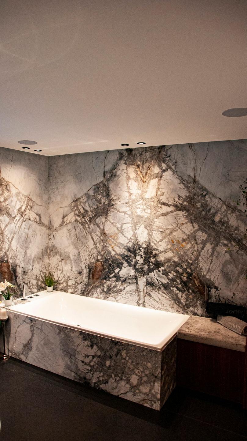 Modernes Bad mit fugenarmen Naturstein-Wandplatten