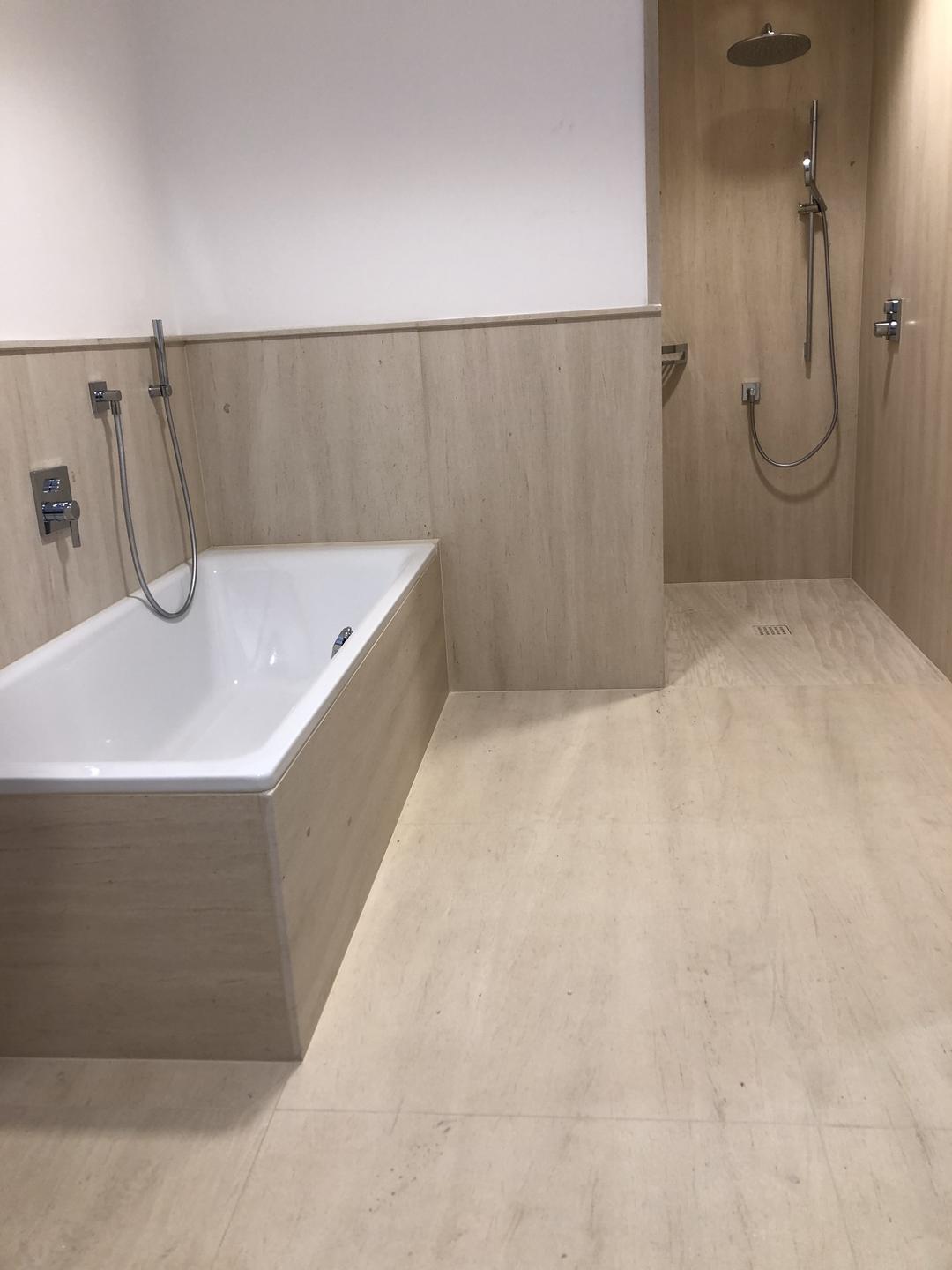 Badezimmer mit Natursteinboden und passenden Wandplatten