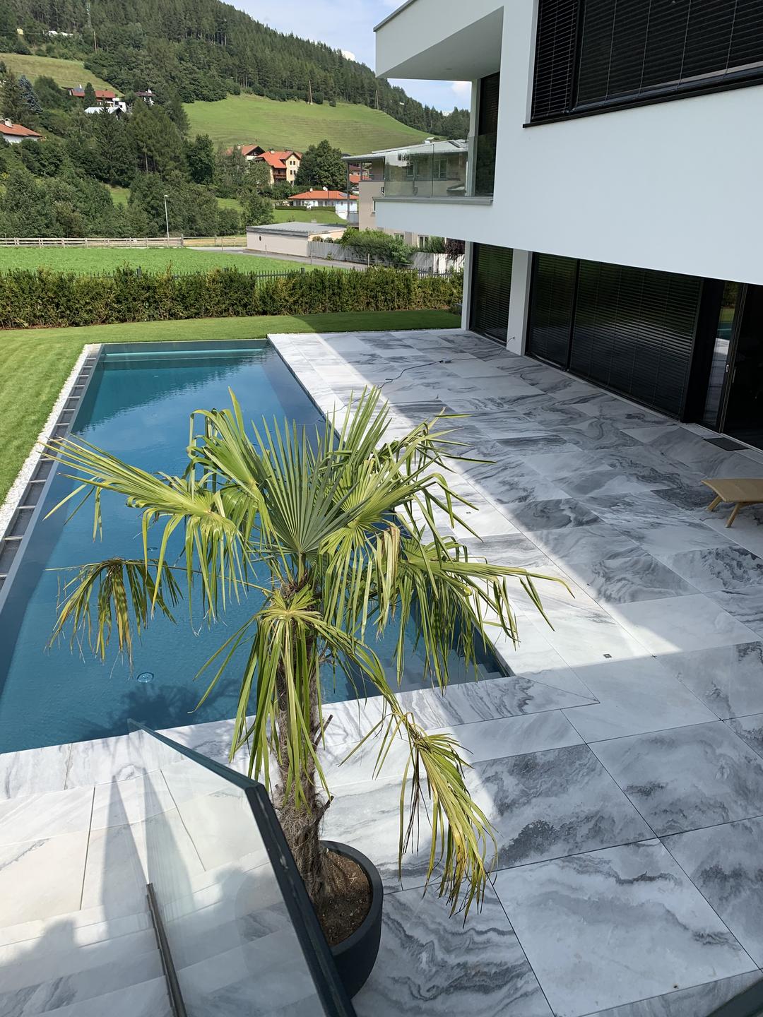 Außenbereich mit Natursteinboden und Pool